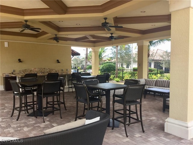 view of patio / terrace with ceiling fan, fence, and outdoor dining space