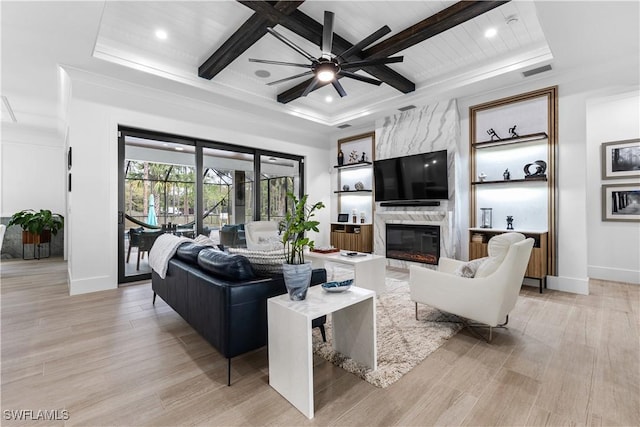 living area featuring beam ceiling, visible vents, a high end fireplace, light wood-type flooring, and coffered ceiling