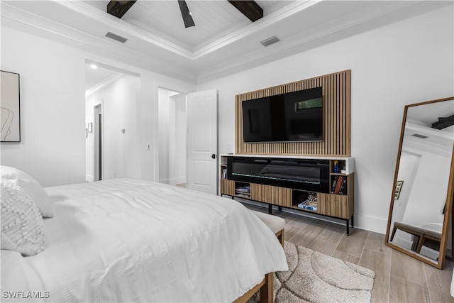 bedroom with ceiling fan, wood finished floors, visible vents, and baseboards