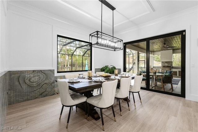 dining room with light wood-type flooring and crown molding