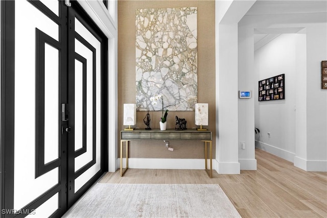 foyer entrance with light wood-type flooring and baseboards