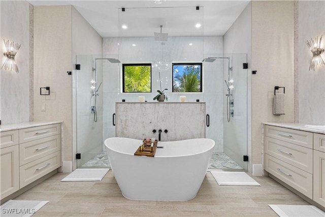 full bathroom featuring recessed lighting, a freestanding tub, a shower stall, and vanity