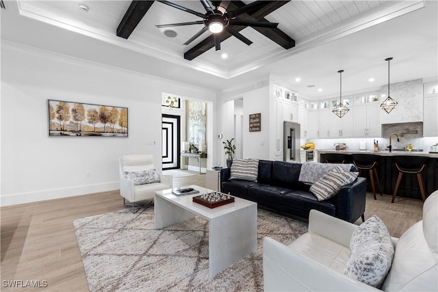 living area with baseboards, a ceiling fan, beamed ceiling, light wood-style floors, and recessed lighting