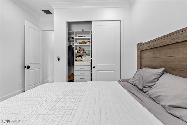 bedroom with a closet, visible vents, and baseboards