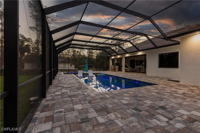 pool featuring glass enclosure and a patio