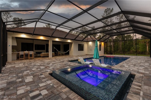 pool with a patio area, outdoor lounge area, and an in ground hot tub