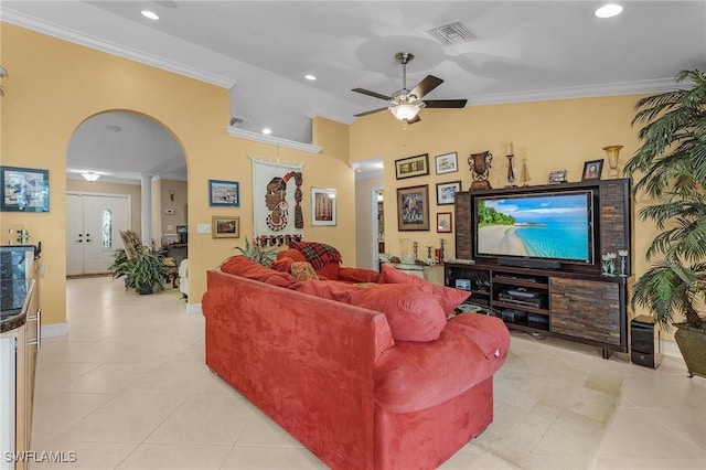 living room featuring arched walkways, visible vents, crown molding, and light tile patterned floors