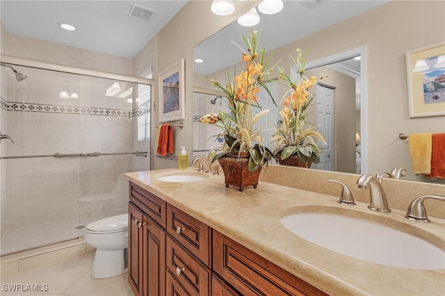 bathroom featuring toilet, a stall shower, a sink, and visible vents