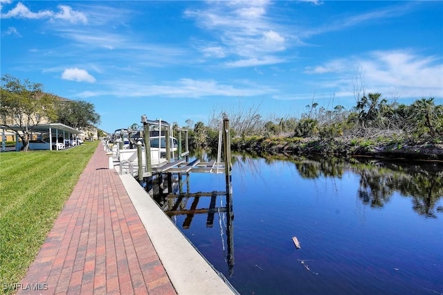 dock area with a water view, a lawn, and boat lift