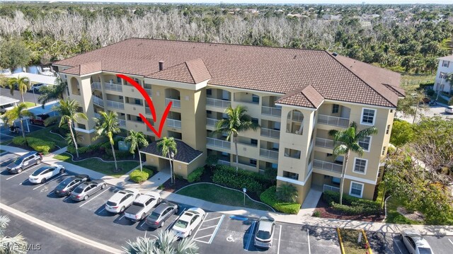 view of property with uncovered parking and a forest view