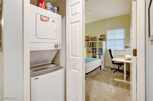 laundry room with laundry area, carpet floors, and stacked washer / drying machine