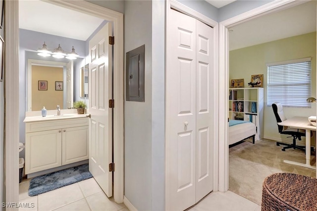 bathroom featuring tile patterned flooring, vanity, electric panel, and baseboards