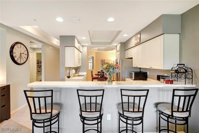 kitchen featuring stainless steel appliances, recessed lighting, white cabinetry, and a peninsula