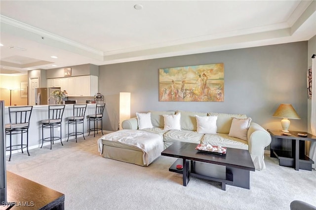 living area featuring crown molding, a tray ceiling, and light colored carpet