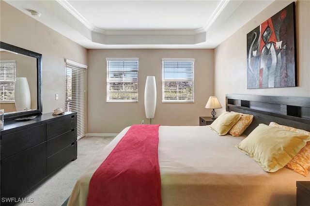 bedroom with baseboards, a raised ceiling, crown molding, and light colored carpet