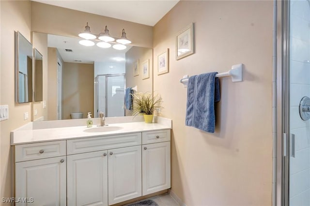 full bathroom featuring toilet, a stall shower, visible vents, and vanity