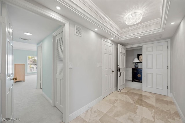 hall with baseboards, visible vents, ornamental molding, a tray ceiling, and recessed lighting