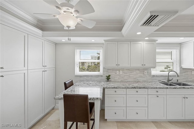 kitchen featuring ornamental molding, a sink, visible vents, and a healthy amount of sunlight