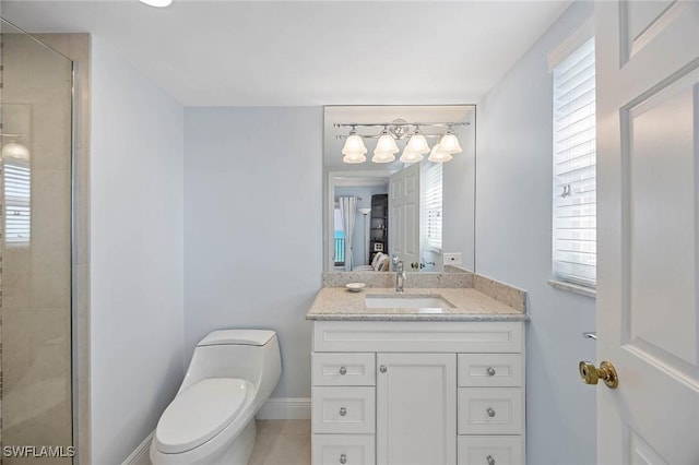 bathroom featuring vanity, a shower stall, toilet, and baseboards