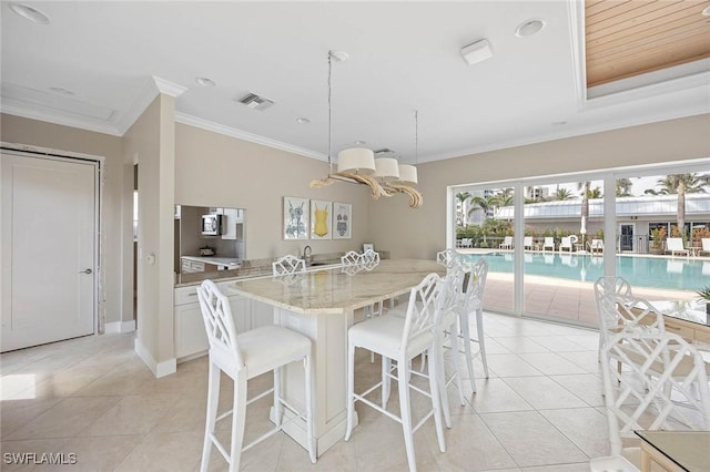 dining room featuring light tile patterned floors, baseboards, visible vents, and crown molding