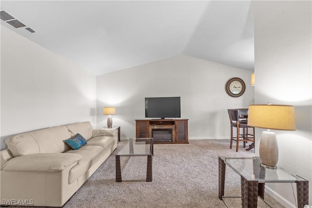 carpeted living area with lofted ceiling, visible vents, and baseboards