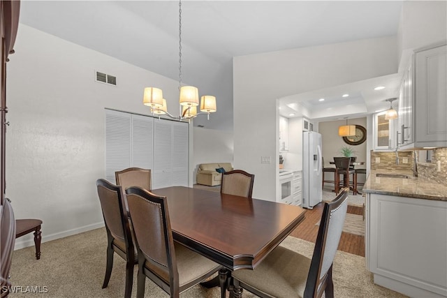 dining space with baseboards, visible vents, a raised ceiling, a chandelier, and recessed lighting