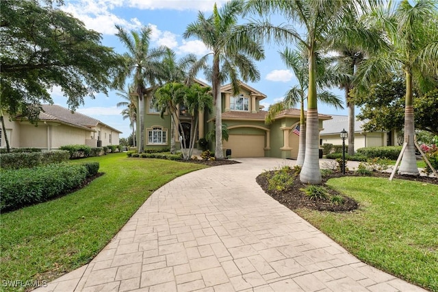 view of front of house featuring decorative driveway, a front yard, and stucco siding