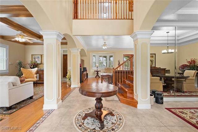 entrance foyer with a healthy amount of sunlight, ornate columns, and light tile patterned floors