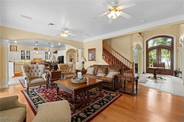 living room with arched walkways, french doors, visible vents, and ornate columns