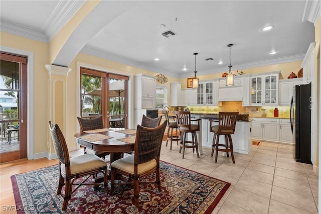 dining space with arched walkways, french doors, light tile patterned floors, recessed lighting, and ornamental molding