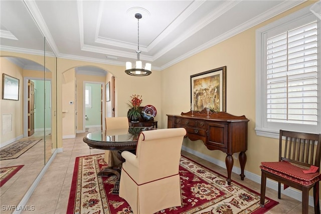 dining room with arched walkways, light tile patterned floors, a raised ceiling, a chandelier, and baseboards