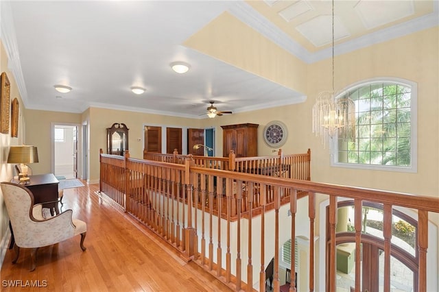 hall featuring ornamental molding, light wood finished floors, an upstairs landing, and an inviting chandelier