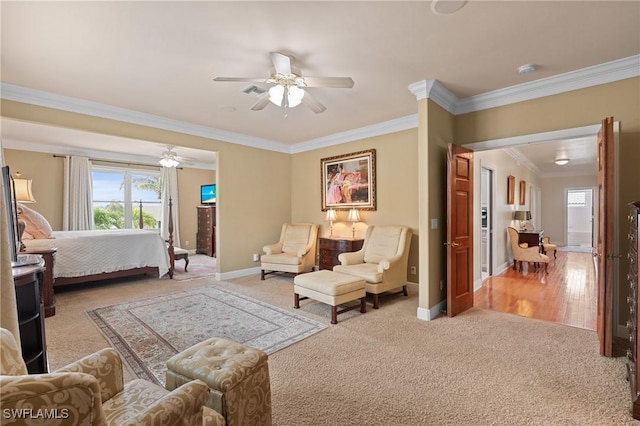 bedroom with light carpet, ceiling fan, baseboards, and crown molding