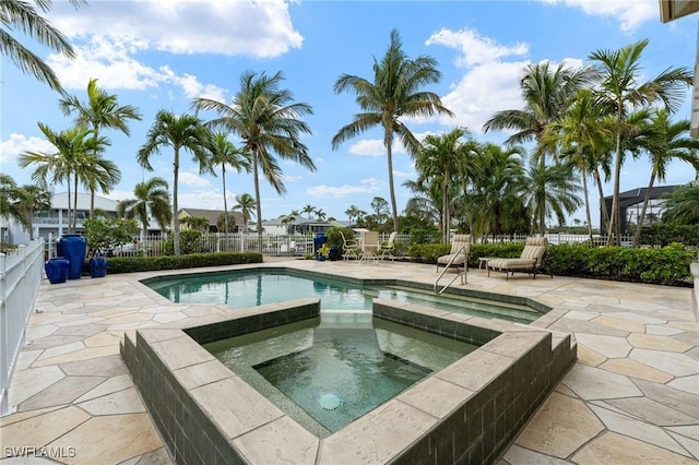 view of pool with an in ground hot tub, a patio, and fence