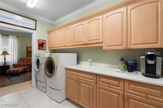 laundry area with cabinet space, ornamental molding, separate washer and dryer, a sink, and light tile patterned flooring