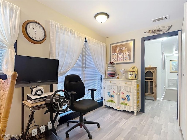 office featuring light wood finished floors, baseboards, and visible vents