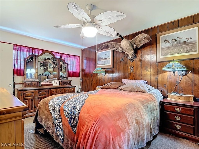 bedroom featuring ceiling fan, carpet floors, and wooden walls