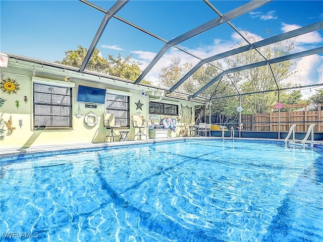 view of swimming pool with a fenced in pool, glass enclosure, fence, and a patio