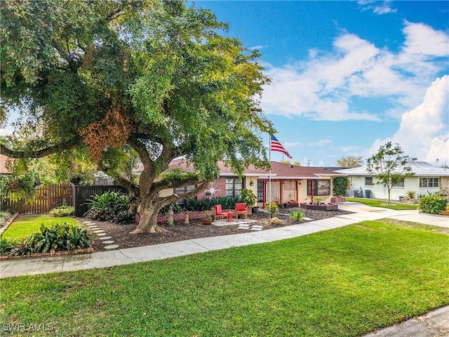 exterior space with driveway, fence, and a front lawn