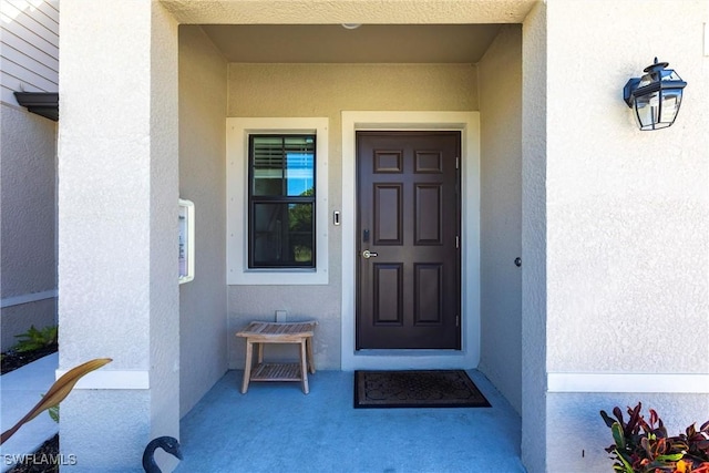 view of exterior entry featuring stucco siding