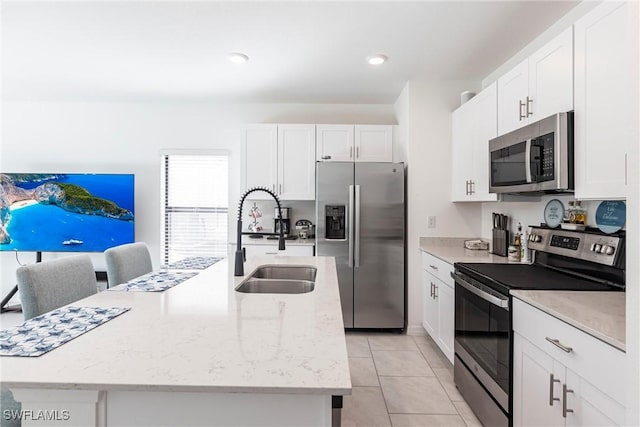 14239 Oviedo Pl, Fort Myers, FL 33905 - kitchen with stainless steel appliances, a center island with sink, a sink, and white cabinetry