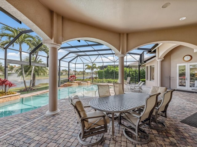 view of patio with a lanai and a pool with connected hot tub