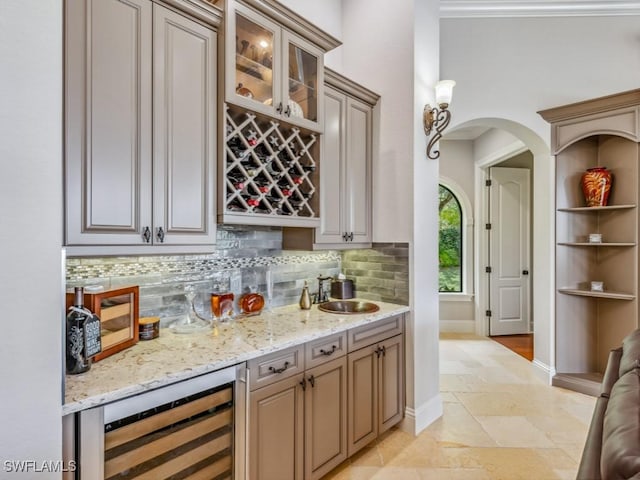 bar featuring stone tile floors, arched walkways, decorative backsplash, wine cooler, and indoor bar