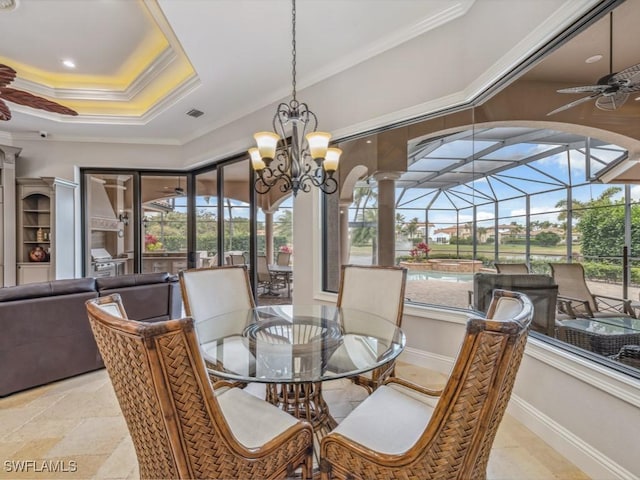 dining room with a wealth of natural light, a raised ceiling, ornamental molding, and a sunroom