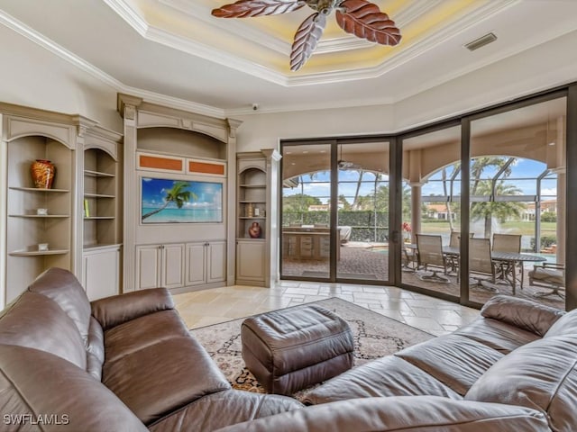 living room with stone tile floors, visible vents, a raised ceiling, and a sunroom