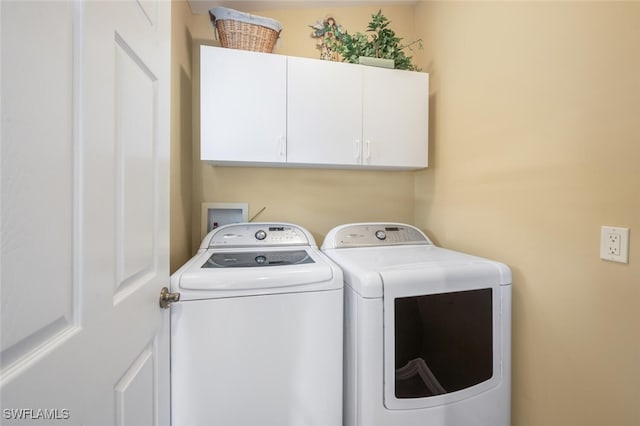 washroom with washing machine and clothes dryer and cabinet space