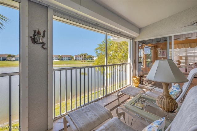 sunroom featuring vaulted ceiling and a water view