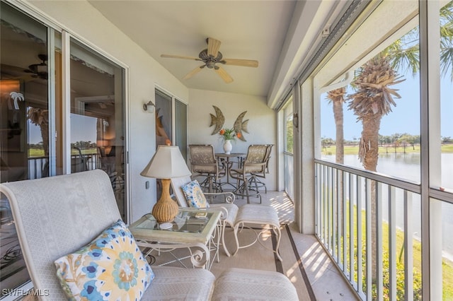 sunroom / solarium featuring a ceiling fan and a water view