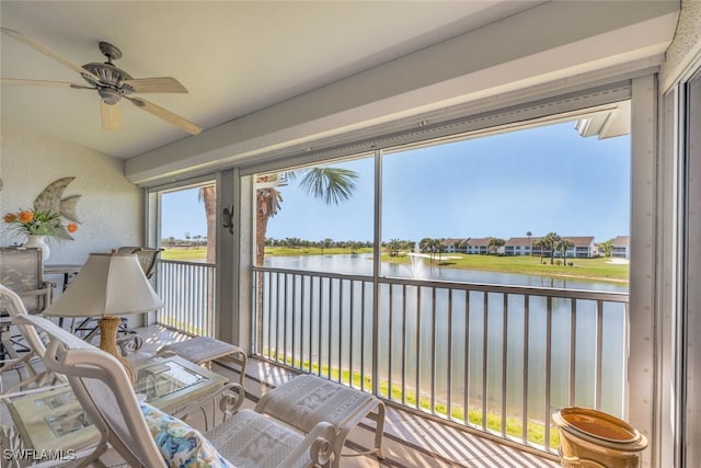 sunroom / solarium featuring a water view and a ceiling fan