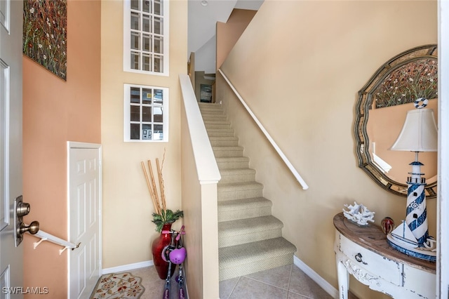 stairs featuring tile patterned floors and baseboards